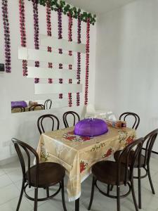 un tavolo con sedie e un cuscino viola sopra di MAM Guesthouse Kota Tinggi a Kota Tinggi