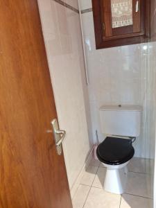 a bathroom with a black toilet and a wooden door at Charmante maison en pleine montagne basque in Saint-Jean-Pied-de-Port