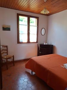 a bedroom with a bed and a window and a chair at Charmante maison en pleine montagne basque in Saint-Jean-Pied-de-Port