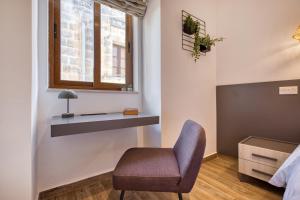 a chair sitting in a room with a window at Studio apartment 2 with private kitchenette at the New Casa Vittoria by SF Homes in Cospicua +37 photos