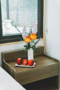 a vase with flowers and two apples on a shelf at Dragon Mountain Home in Ninh Binh - Center Of Heritage in Ninh Binh +115 photos