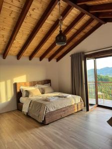 a bedroom with a large bed with a balcony at Bujtina Salko in Muçaj