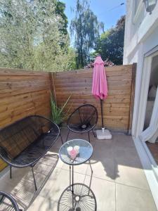 a patio with two chairs and a table and an umbrella at appartement cosy entier et parking privé sur place a 5min de lille et 10 min du Stade Pierre Mauroy in Mons-en-Baroeul