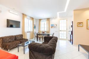 a living room with a couch and chairs and a table at Villa Arvilla with Private POOL in Campofelice di Roccella +33 photos