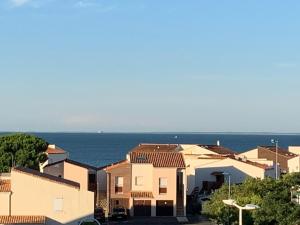a group of houses with the ocean in the background at Appartement quartier des Minimes avec piscine, parking, en bordure du port à La Rochelle in La Rochelle