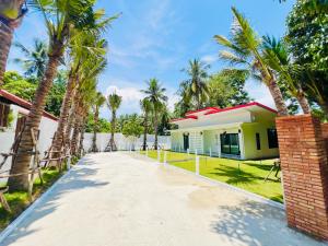 a house with palm trees and a driveway at VS Resortวีเอส รีสอร์ท ท่าศาลา in Ban Thang Khun