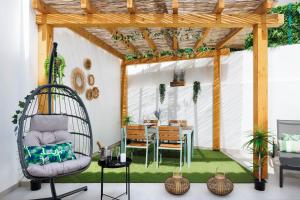a patio with a table and chairs and a pergola at Roots Apartments in Faro