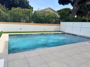 a swimming pool with blue water in a yard at Bel Appartement Tout Neuf in Cavalaire-sur-Mer