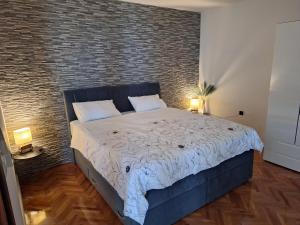Un dormitorio con una cama grande con una pared de ladrillo. en Apartment Little princess Dora, en Senj