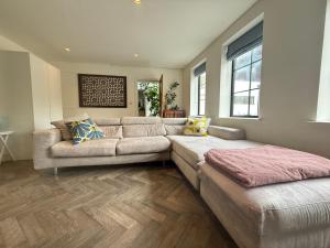 a large living room with a couch and a table at Studio with kitchen nestled lovely wooded cul du sac in New Malden