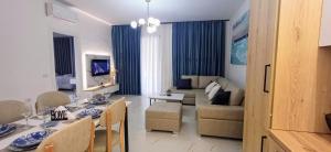 a living room with a couch and a dining room at Serendipity Apartment Radhime in Radhimë