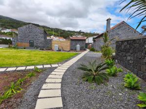 a stone pathway in front of a house at Cá Por Casa Pico-Faia in Prainha de Baixo