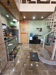 a living room with a staircase and a kitchen at Guillermo Residence in Malaybalay