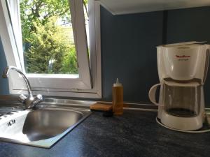 a kitchen counter with a coffee maker next to a sink at Camping Calme et Nature in Castellane