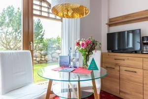 a glass table in a living room with a vase of flowers at Strandhaus Claassen 01 in Ahrenshoop