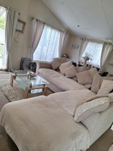 a living room with two couches and a table at Highfields Holiday Park Clacton in Clacton-on-Sea