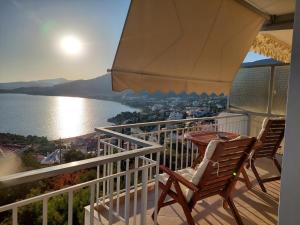 a balcony with a table and chairs and a view of the water at Lina's view apartment in Paleo Tsifliki