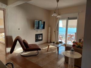 a living room with a couch and a chair and a table at Lina's view apartment in Paleo Tsifliki