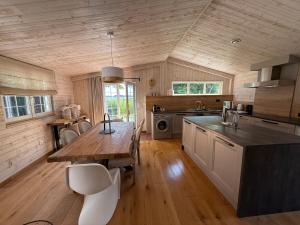 a kitchen with a wooden table and a wooden floor at O Vran, suspends your flight-ACCES PLAGE-parc naturel prive in Ile aux Moines