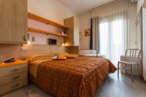 una habitación de hotel con una cama y una ventana en Hotel Deborah, en Milano Marittima 265 fotos más