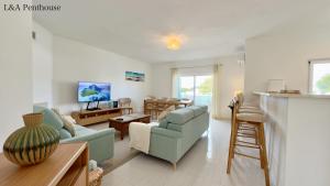 un soggiorno con divani e una sala da pranzo di Penthouse L&A Prainha with sea view, 2 Terraces ad Alvor