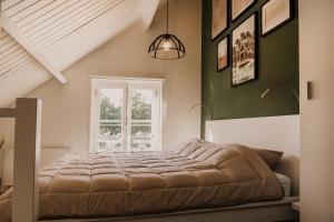 a bedroom with a large bed in front of a window at Vakantiehuisje Dichtbij Zee in Vlissingen