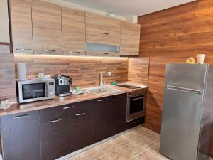 a kitchen with a stainless steel refrigerator and a microwave at Sea View 1 Bedroom Apartment - Pool & Free Parking - Kavarna in Kavarna