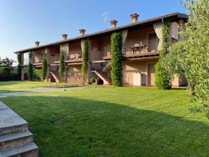 ein großes Gebäude mit einem Rasen davor in der Unterkunft La Maison in Franciacorta in Colombaro
