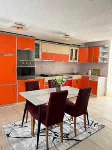 a kitchen with orange cabinets and a table and chairs at MARIS apartman - NEUM in Neum