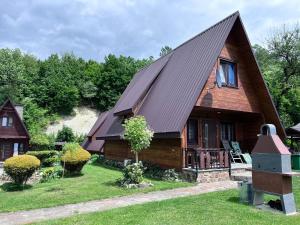 a wooden house with a gambrel roof at Domki pod Skałką in Baligród