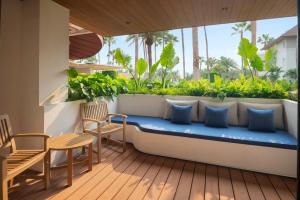 a balcony with a blue bench and a table and chairs at Amari Bangsaen in Bangsaen