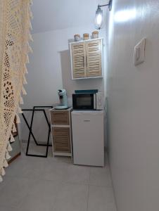 a small kitchen with a microwave and a refrigerator at La chambre de Ptitruc au coeur du maquis in Granace +17 photos