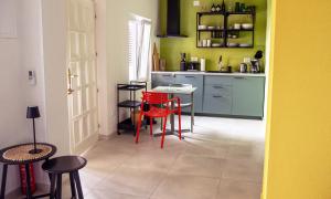 a kitchen with red chairs and a table in it at holiday by the sea in Marusici 