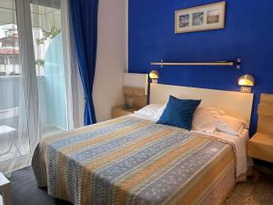 een slaapkamer met een groot bed met een blauwe muur bij Bed and Breakfast Villa Giovanna in Rimini