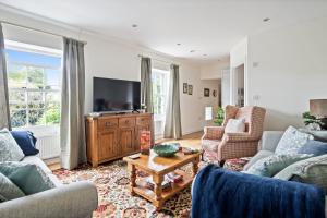 布罗肯赫斯特Central Brockenhurst flat near pubs & trails的有两张沙发和一台电视的客厅