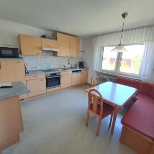 a kitchen with a table and a table and chairs at Monteurwohnung Ferienhof Arold in Creglingen +4 photos