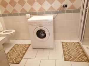 Casa Murru في غيراسول: غسالة ملابس في حمام مع مرحاض