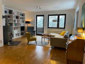 a living room with a couch and a chair at Großzügige individuelle Wohnung am Starnberger See in Münsing am Starnberger See
