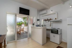 een keuken met witte apparatuur en een eetkamer bij Lina and Babis' Home in Adamas