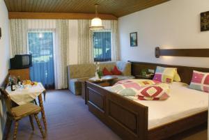 a bedroom with a large bed and a living room at Klausenhof in Pertisau