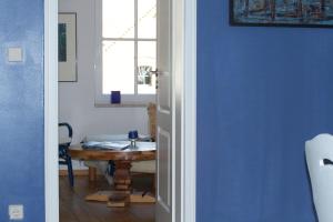 a blue room with a table and a window at Pension Kunsthof Dahrenstedt in Dahrenstedt