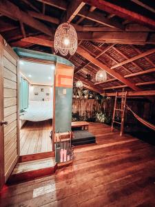 a bedroom with a bed in a room with wooden floors at Jeepney Siargao in General Luna
