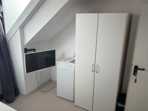 a room with a white cabinet and a tv at Marstall Apartmenthaus Kassel in Kassel