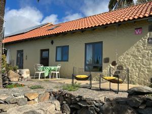 a house with chairs and a table in front of it at Casa Buenavida in Alajeró