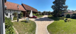 a gravel path in front of a house with a umbrella at Studio en baie de Somme in Villers-sur-Authie