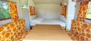 a small room with a bed and a table at Caravane vintage in Camoël