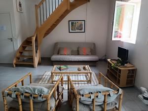 a living room with a couch and a table at Duplex dans belle propriété avec piscine in Les Essarts-le-Roi