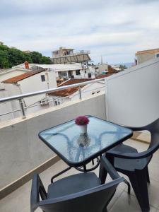 a glass table and a chair on a balcony at Beach Center in Ulcinj