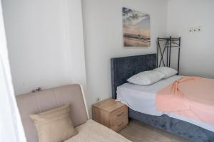 a small bedroom with a bed and a chair at Beach Center in Ulcinj