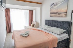 a bedroom with a large bed with an orange blanket at Beach Center in Ulcinj